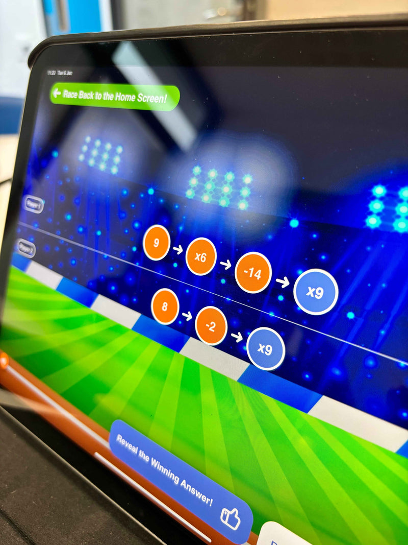 Close-up of a tablet screen displaying a math game with colorful interface